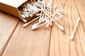 Wood cotton swabs are scattered out of the box. Place for text. Wood background Royalty Free Stock Photo