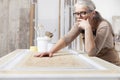 Wood crafts, woman artisan carpenter in workshop, wearing overall and eyeglasses, think, check and plan the work, interior Royalty Free Stock Photo