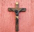 Wood crucifix on a pink background