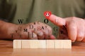 Wood cube with illustration latters red smile heart at index finger idea concept