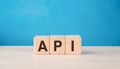 Wood cubes with abbreviation text API on wooden table. Application Programming Interface