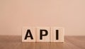 Wood cubes with abbreviation text API on wooden table. Application Programming Interface