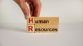 Wood cubes and blocks with words `HR, human resources` on white background, copy space. Male hand. Business, employment and huma Royalty Free Stock Photo