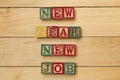 Wood cubes on wooden table with words New Year new job cool