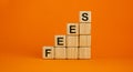 Wood cubes with word `fees` stacking as step stair on beautiful orange background, copy space. Business concept Royalty Free Stock Photo