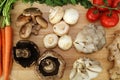 Wood cutting board in kitchen table with fresh ingredients carrot, mushroom, potatoes, tomatoes, food many colors orange, red. Royalty Free Stock Photo