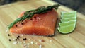 Wood cutting board in kitchen table with fresh red salmon fish salt pepper and lime ready to cook. Royalty Free Stock Photo