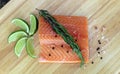 Wood cutting board in kitchen table with fresh red salmon fish salt pepper and lime ready to cook. Royalty Free Stock Photo