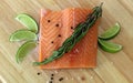 Wood cutting board in kitchen table with fresh red salmon fish salt pepper and lime ready to cook. Royalty Free Stock Photo