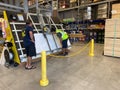 The wood cutting station at Lowes home improvement store where an employee is setting up his saw to cut wood for a customers