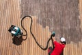 Wood deck repair top view, man sanding gray ipe boards with orbital power sander connected to dust collector Royalty Free Stock Photo