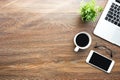 Wood desk table with smartphone with blank mock up screen, laptop computer and up of coffee with sun light in the morning. Top Royalty Free Stock Photo