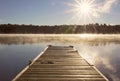 Wood dock over a calm lake with fog in the early morning Royalty Free Stock Photo