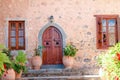 Wood door and windows with wooden shutters on pink colored wall Royalty Free Stock Photo