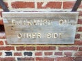 Wood entrance on other side sign on brick wall Royalty Free Stock Photo