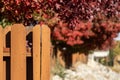 Brown wood fence fall background. Red trees in autumn backdrop. Royalty Free Stock Photo