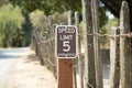 Wood fence in the park with 5 speed limit street sign