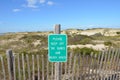 wood fence and sand dunes at the beach with please keep off sign Royalty Free Stock Photo