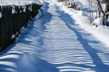 Wood fence shadow in snow. Winter scene in mountains on cold day. Landscape. Royalty Free Stock Photo