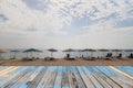 Wood floor on beach chairs and colorful umbrella on tropical beach, blue sky and cloud background. Royalty Free Stock Photo