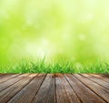 Wood floor with green bokeh and Fresh spring green grass and sunlight