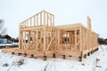 Wood frame house under construction, bare frame with pile foundation, winter season Royalty Free Stock Photo