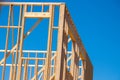 wood framing structure at new property development site new home currently under construction against blue sky Royalty Free Stock Photo