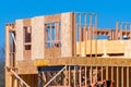 wood framing structure at new property development site new home currently under construction against blue sky Royalty Free Stock Photo