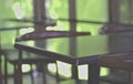 Desk, empty wooden chairs in the shop, outdoor light background, natural green Brightness from the outside