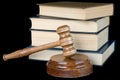 Wood gavel and books on a black background