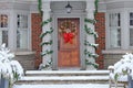 Wood grain front door of house with colorful Christmas wreath Royalty Free Stock Photo