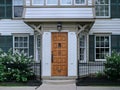 Wood grain front door of old fashioned white clapboard house