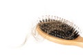 Wood hairbrush on white background. Close-up with long brown hair Royalty Free Stock Photo