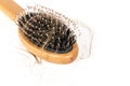 Wood hairbrush on white background. Close-up with long brown hair Royalty Free Stock Photo