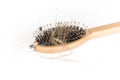 Wood hairbrush on white background. Close-up with long brown hair and syringe to illustrate hair loss treatment medicine
