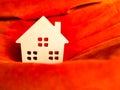 Wood home toy on vivid orange fabric. Build home or home loan concept
