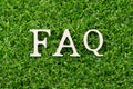 Wood letter in word FAQ Abbreviation of Frequently asked questions on green grass background Royalty Free Stock Photo