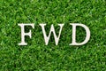 Wood letter in word FWD Abbreviation of forward on green grass background