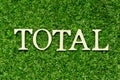Wood letter in word total on green grass background