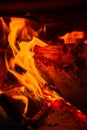 Wood log burning in the chimenea. Fire wood, coal and amber ash closeup. Red tongues of flame and glowing amber. Royalty Free Stock Photo