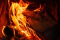 Wood log burning in the chimenea. Fire wood, coal and amber ash closeup. Red tongues of flame and glowing amber.