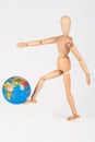 Wood mannequin kick a world globe in disrespect isolated Royalty Free Stock Photo