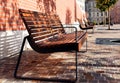 wood and metal park benches in a row. urban setting. cobblestone street pavement. small trees with cast iron grate. Royalty Free Stock Photo