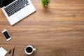 Wood office desk table with laptop computer, smartphone, cup of coffee and supplies. Top view with copy space, flat lay Royalty Free Stock Photo