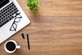 Wood office desk table with laptop, cup of coffee and supplies. Top view with copy space, flat lay Royalty Free Stock Photo