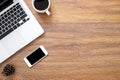 Wood office desk table with smartphone, laptop and cup of coffee. Top view with copy space, flat lay Royalty Free Stock Photo