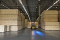 Wood pallet forklift driving at a factory floor inside a shed