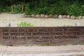 A wood park bench with an engraved quote from Cindi Morgan Dyke surrounded by a plant lined walking path in Wisconsin Royalty Free Stock Photo