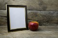 Wood photo frame and red apple on wooden table Royalty Free Stock Photo