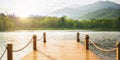 Wood pier dock quiet calm ripple lake with green forest mountain sunny day wide for background Royalty Free Stock Photo
